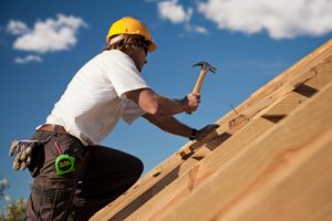 Dachdecker bei der Arbeit mit Schutzhelm