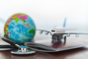 Gesundheitsversorgung und Reiseversicherungskonzept. Stethoskop , Passdokument, Flugzeug und Globus